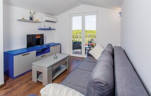 Relax in this stylish space with a sofa, kitchenette, and TV, plus a sliding door to an outdoor area with a view.
