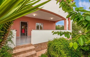 Stunning building with lush green surroundings and a covered entrance.