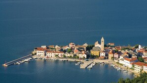 An aerial view of a coastal town with a marina, buildings with red-tiled roofs, and a prominent tower. - Beautiful home in Vinjerac with sauna (Vinjerac)