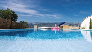 A clear blue swimming pool with a view of mountains in the background. - Beautiful home in Vinjerac with sauna (Vinjerac)