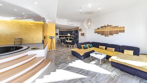 Een moderne woonkamer met een gebogen trap, een eethoek en een keuken.