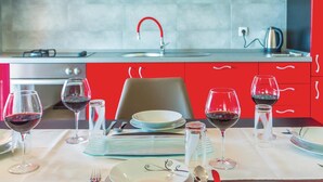 A dining table set with wine glasses and plates, a chair, and a salt and pepper shaker. - 1 bedroom gorgeous apartment in Makarska (Makarska)