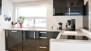 A modern kitchen with a large window, a Bosch coffee maker, and a sink. - Cozy home in Lemvig with WiFi (Lemvig)