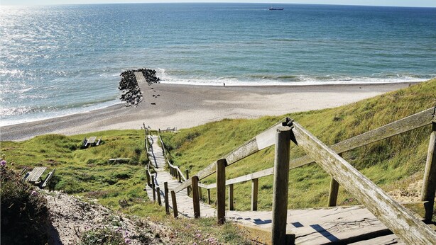 A coastal walkway leading to a beach with a wooden fence and a rocky breakwater. - Cozy home in Lemvig with WiFi (Lemvig)