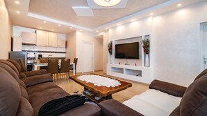 A modern living room with a sofa set, a wooden coffee table, and a TV mounted on the wall. - Awesome home in Islam Latinski (Islam Latinski)