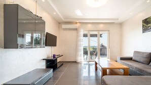 A modern living room with a flat-screen TV, a wooden coffee table, and a sofa. - Awesome home in Islam Latinski (Islam Latinski)