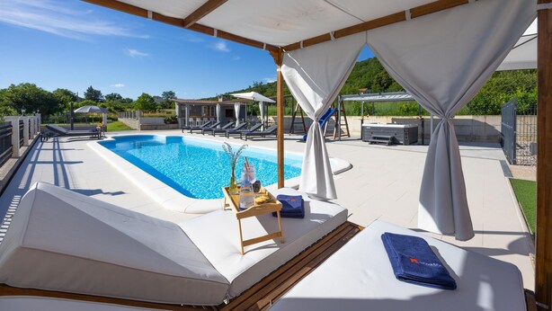 A poolside area with a pool, lounge chairs, and a covered seating area. - Stunning home in Sinj (Sinj)