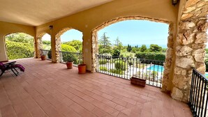 A covered outdoor area with stone arches, potted plants, and a view of a swimming pool. - Villa Rina - relaxing vacations in the hills with beautiful pool exclusively (Avola)