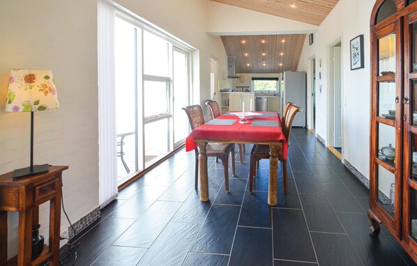 A dining area with a red tablecloth, wooden chairs, and a lamp. - 3 bedroom nice home in Vestervig (Vestervig)