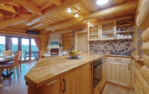 Cozy kitchen with a fireplace, island, and scenic views.