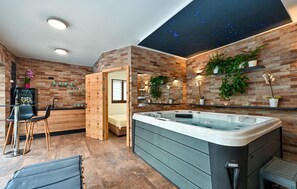 Relax in a spacious bathroom with a large hot tub and seating area.