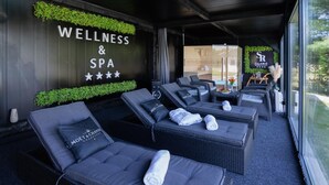 A wellness and spa area with reclining chairs, a wall with greenery, and a sign for Falamig Sport Resort. - Gorgeous home in Fericanci with sauna (Fericanci)