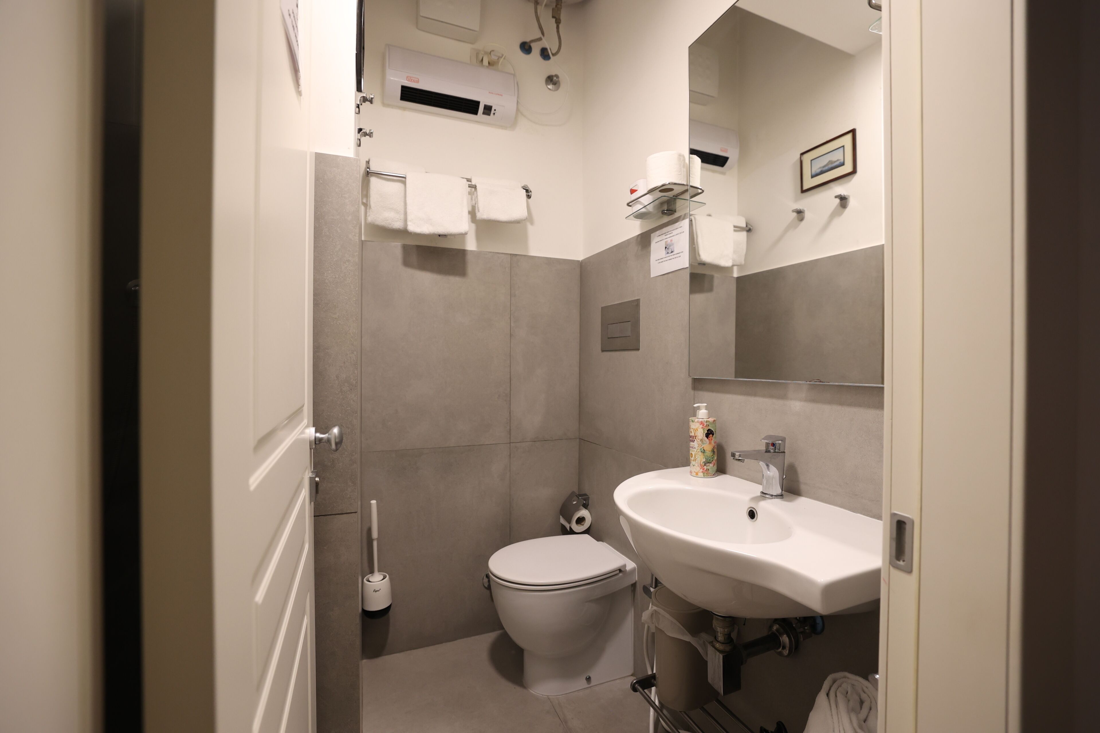 A modern bathroom with a toilet, sink, and towel rack.