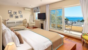 A hotel room with a large bed, a TV, a fireplace, and a balcony with a view of the sea. - Stunning home in Split (Split)