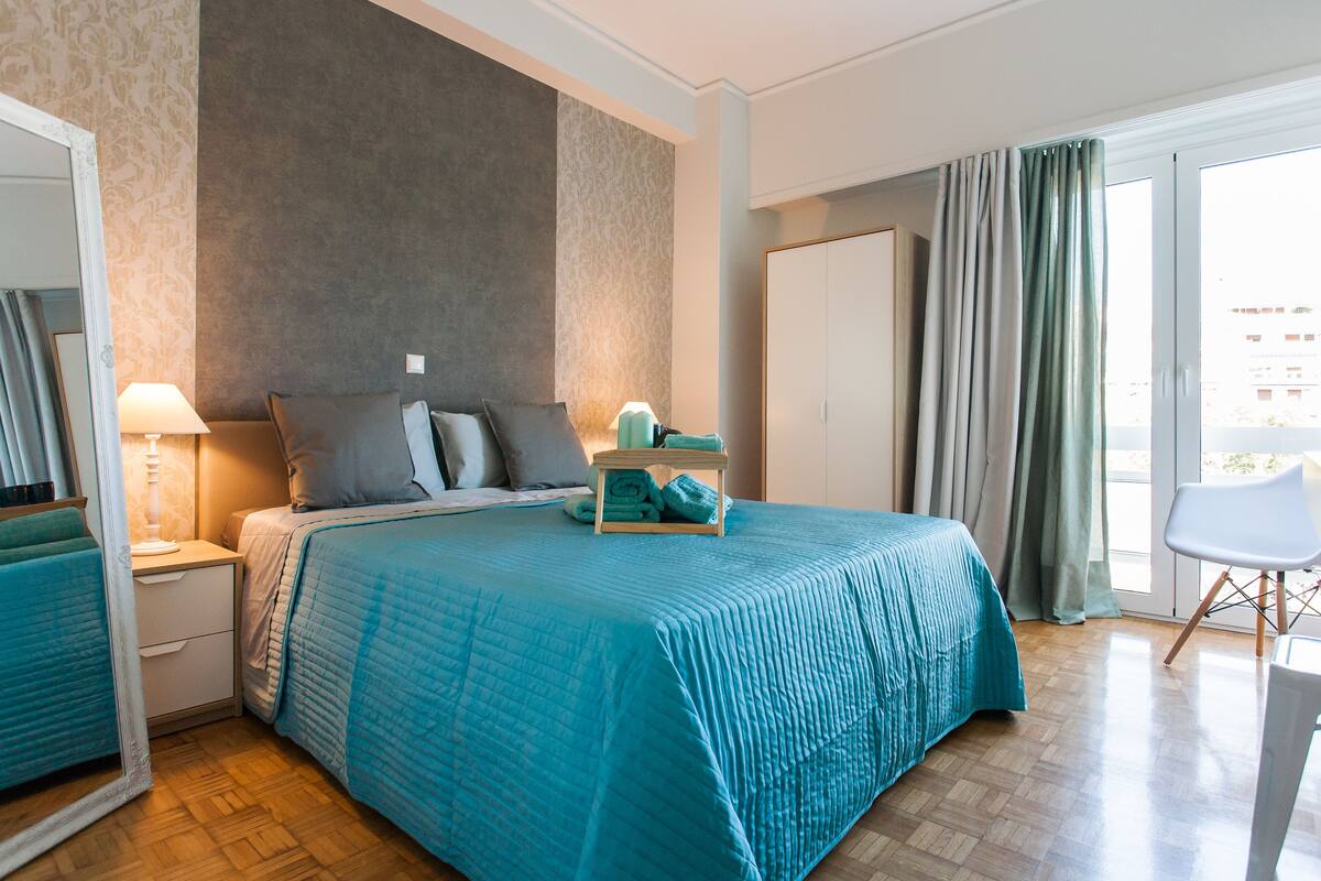 Une chambre d’hôtel avec un grand lit, une table de chevet, une chaise et une armoire.