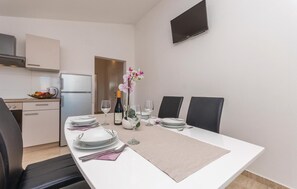 Enjoy meals with family and friends in this spacious dining area, complete with a long table and modern kitchen amenities.