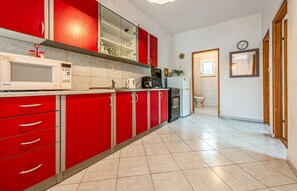 Kitchen features a microwave, coffee maker, and toaster, with a bathroom nearby.