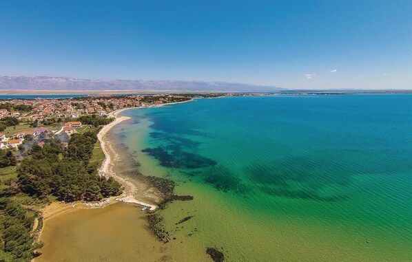 Experience the charm of a Mediterranean coastal town with its red-tiled buildings and picturesque beach.