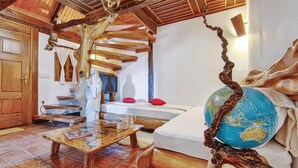 A rustic interior with a wooden ceiling, a globe, and a statue.