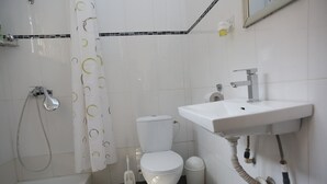 Un bagno con WC, lavabo, doccia e vasca da bagno.