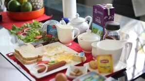Una tavola per la colazione con diversi cibi, tra cui pane tostato, uova e un'insalata.