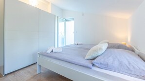 Een moderne slaapkamer met een bed, een kledingkast en een raam.
