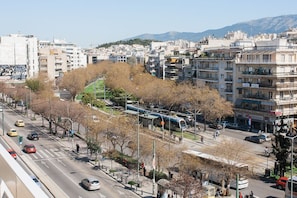 A cityscape with a tram, buildings, and a road.