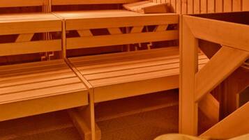 Una sauna con bancos de madera y un cuenco de madera.