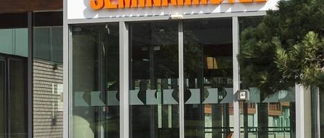 Un bâtiment moderne doté d’une grande façade en verre et d’une enseigne indiquant « SEMINARHOTEL ».