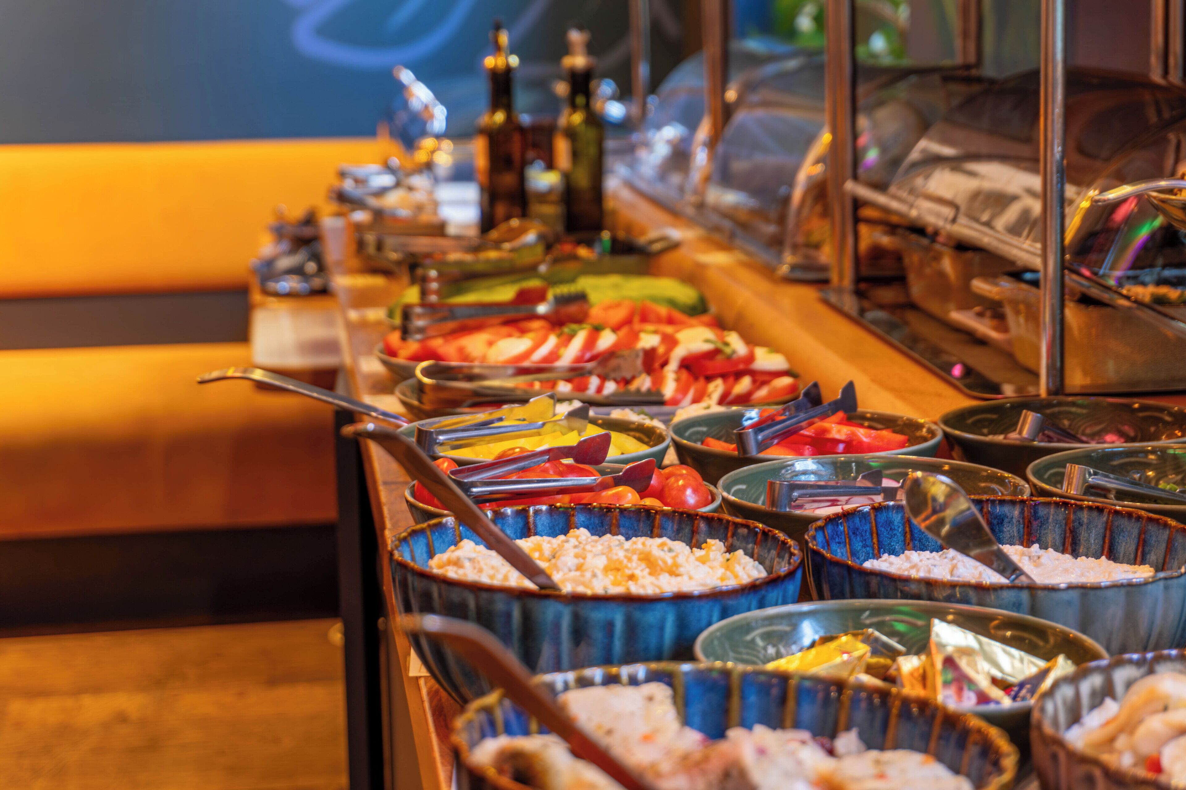 A buffet with various food items and utensils.