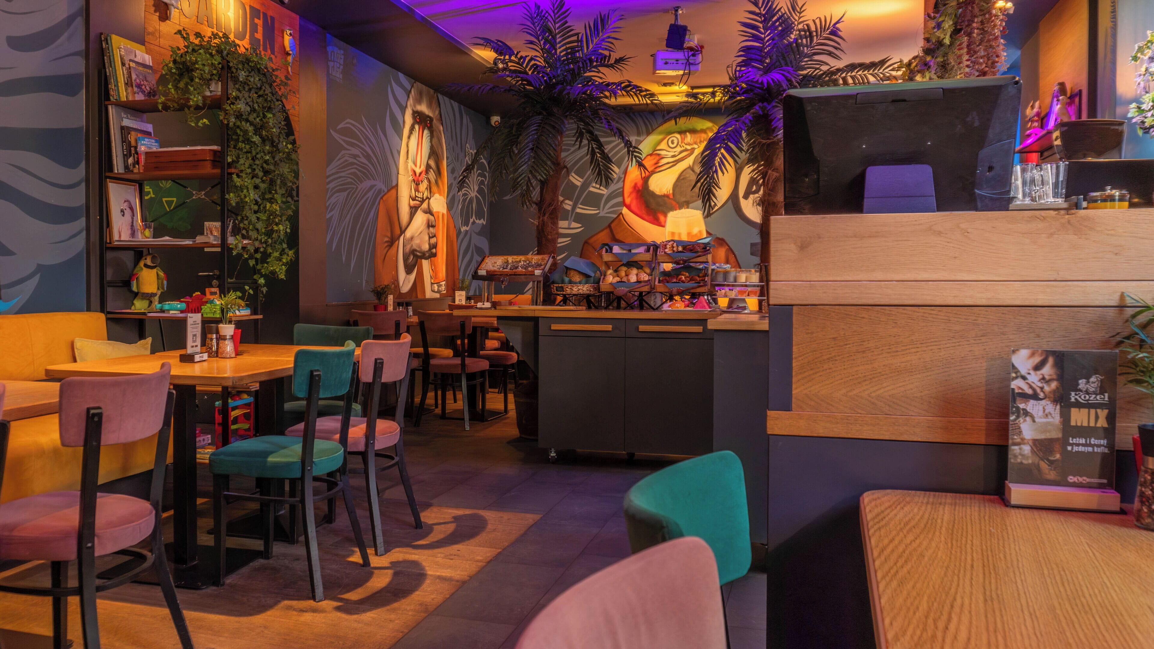 A restaurant interior with a bar area, seating, and a mural on the wall.