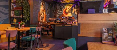 A restaurant interior with a bar area, seating, and a mural on the wall.