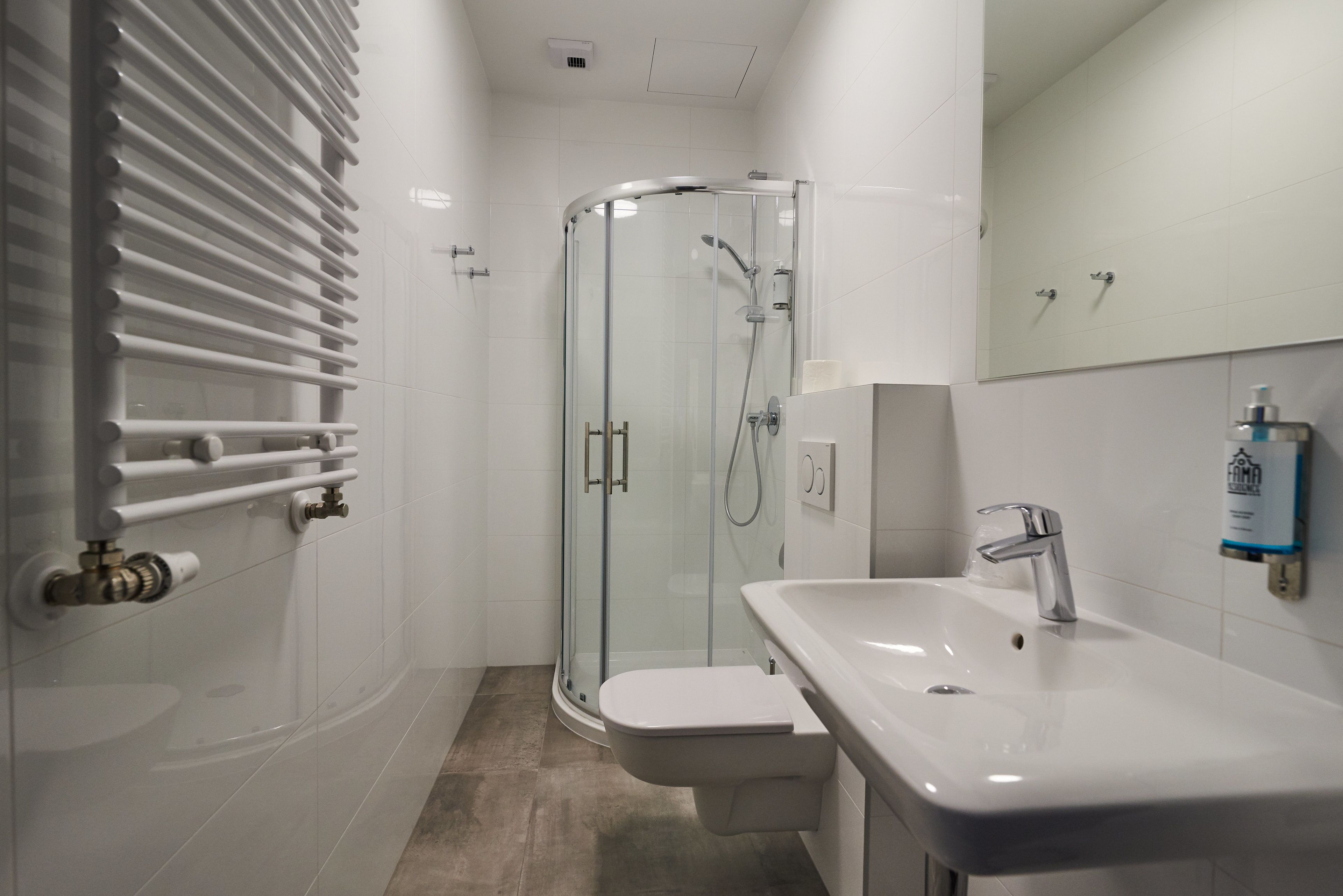 A modern bathroom with a glass-enclosed shower, a white sink, and a toilet.