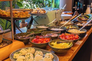 A buffet with various food items and utensils.