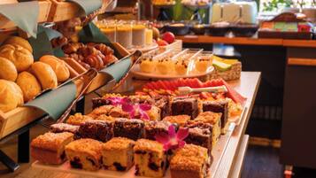 A buffet with various baked goods and desserts.