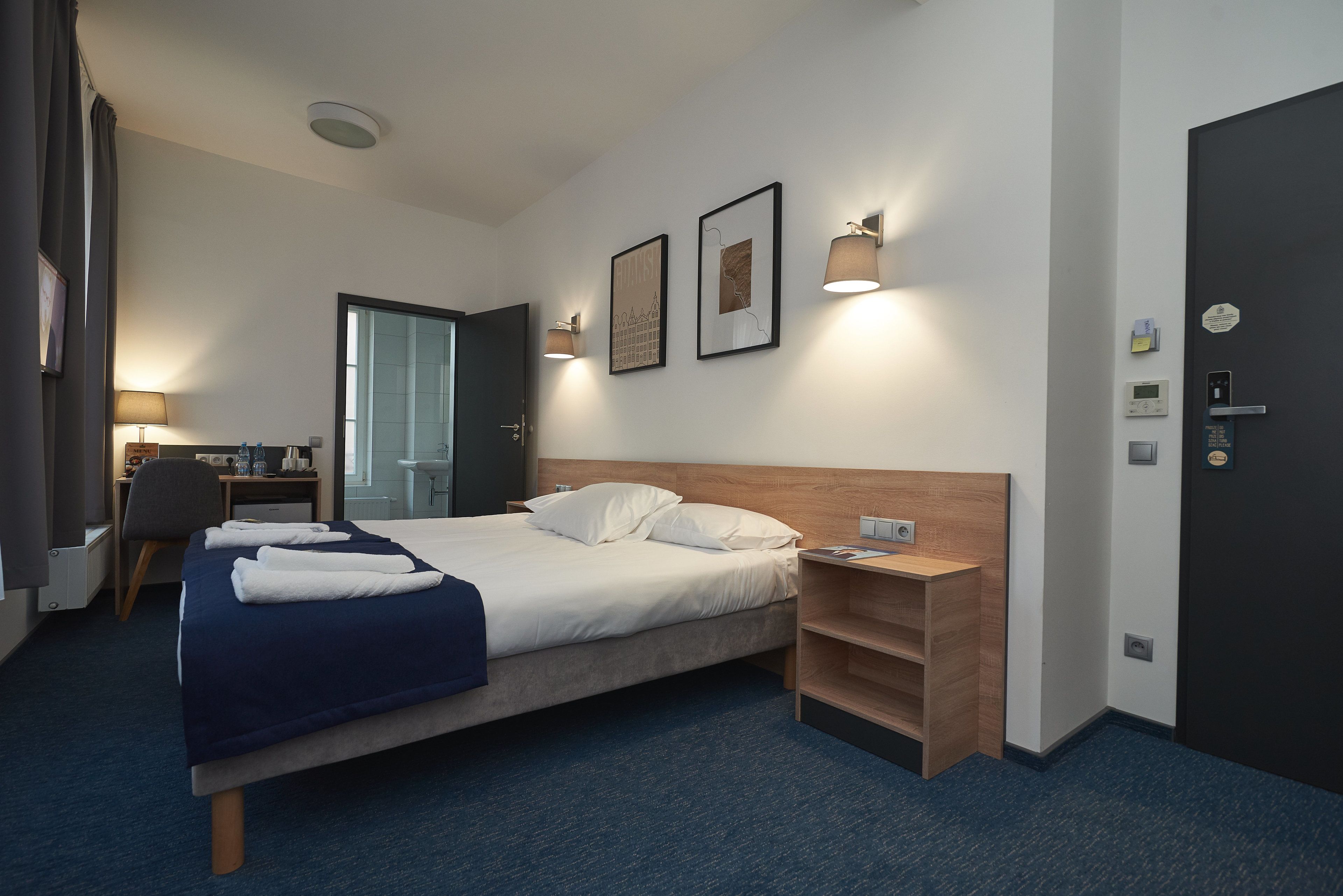 Une chambre d’hôtel comprenant un lit, un bureau, une chaise et une armoire.