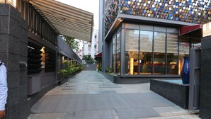 A modern building with a glass facade and a patterned wall. - Hotel Gallery 67 (Kolkata)