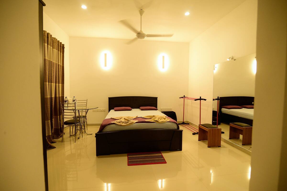 A bedroom with a bed, bedside tables, a ceiling fan, and a mirror.