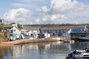 A waterfront with a building labeled 'Harbour Light' and boats docked.