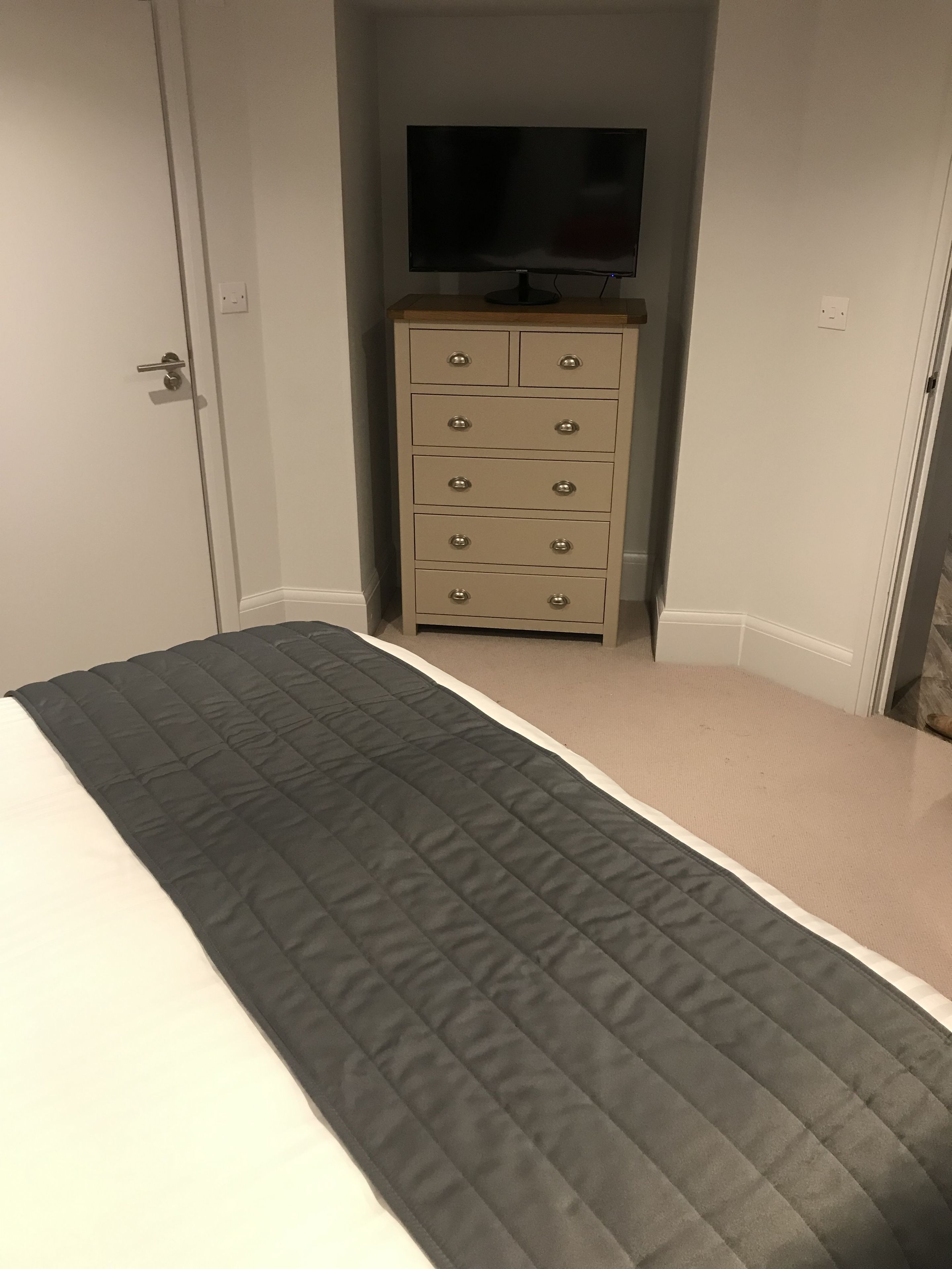 Un dormitorio con cama, cómoda y televisión.