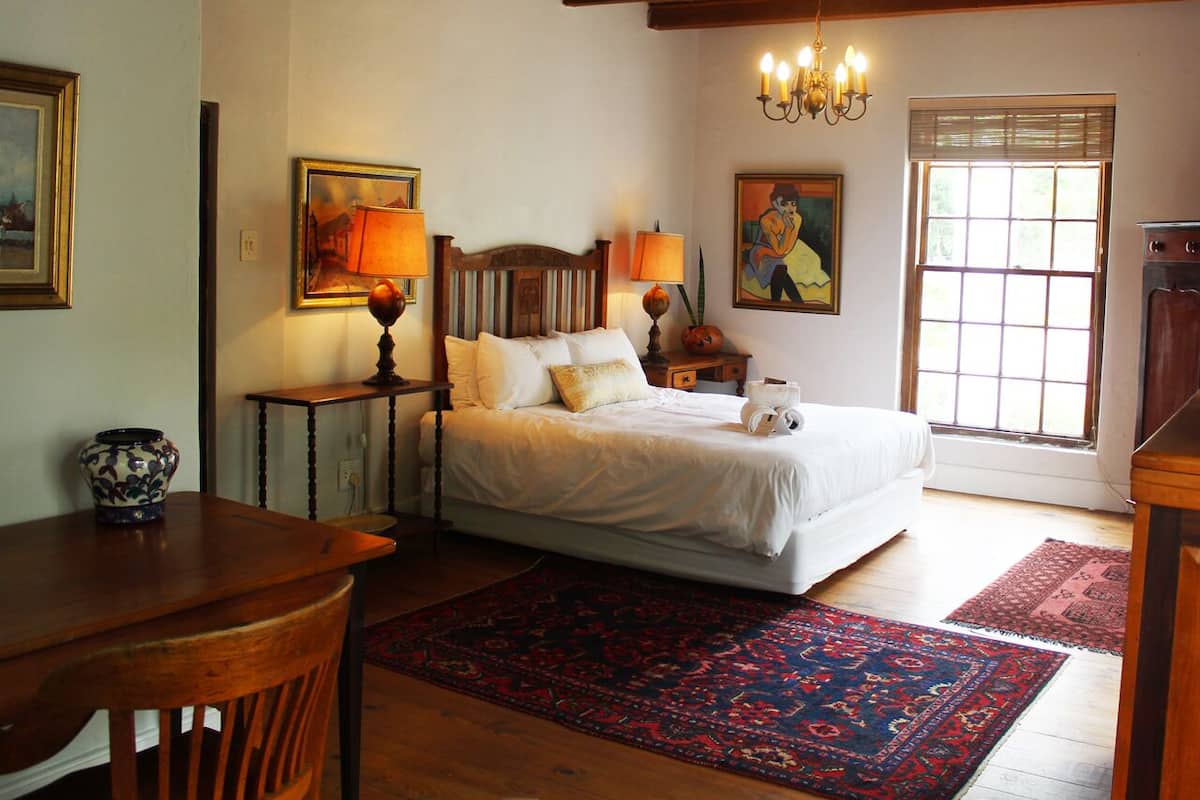 Chambre Double Confort, 1 grand lit, salle de bains attenante, vue montagne | Coin séjour | Livres