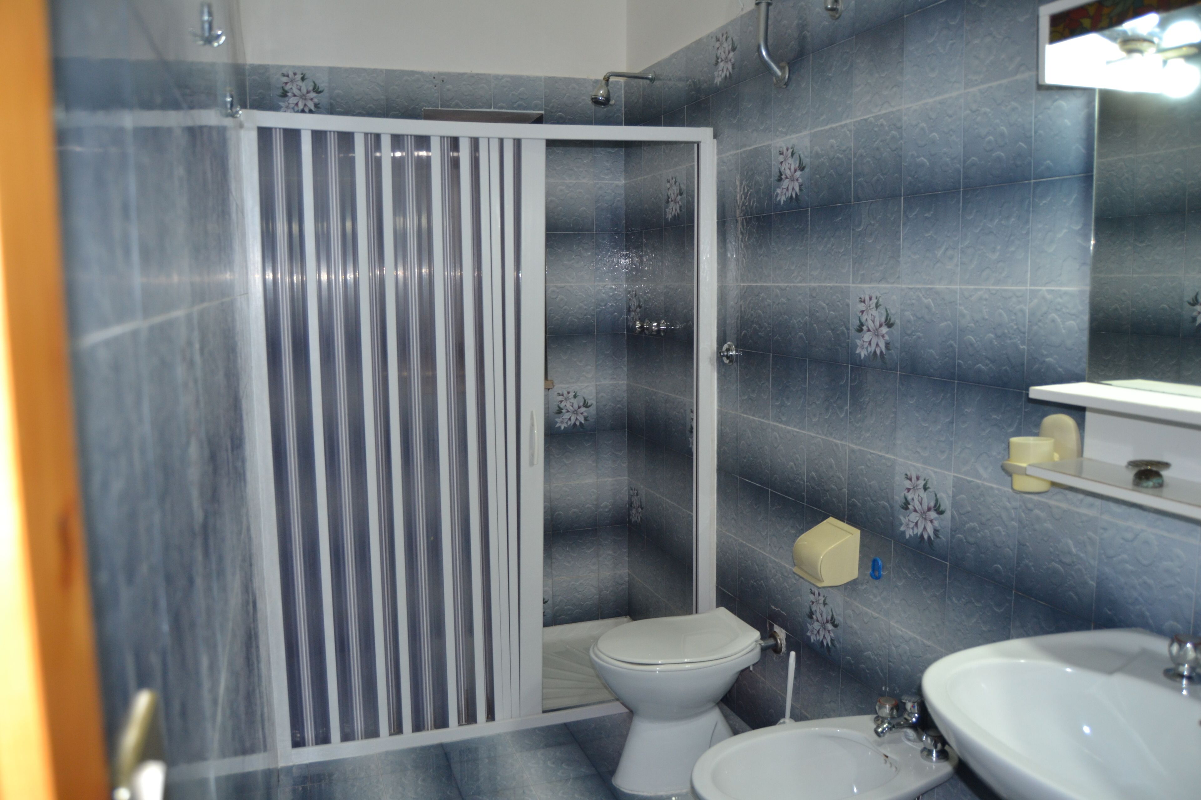 A bathroom with a shower, toilet, and sink.