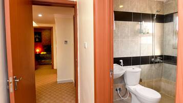Un baño con ducha, inodoro y lavabo.