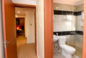 A bathroom with a shower, toilet, and sink.