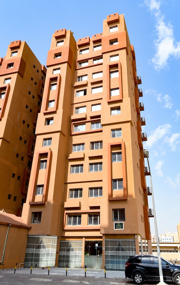 A multi-story building with a modern architectural design, featuring a series of balconies and large windows.