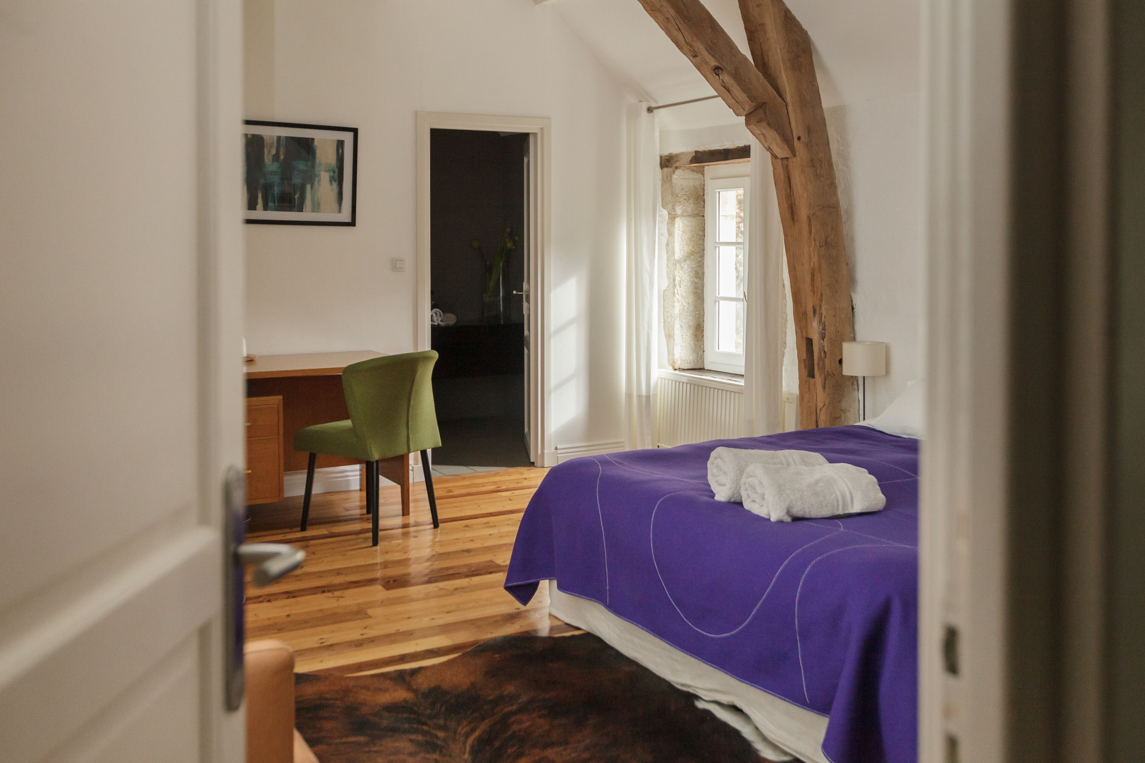 Quarto com cama, escrivaninha e cadeira.