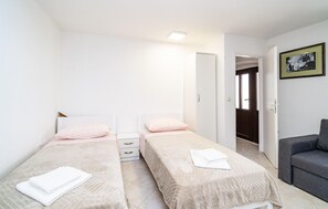 Cozy retreat with two single beds, a wardrobe, and a sofa.