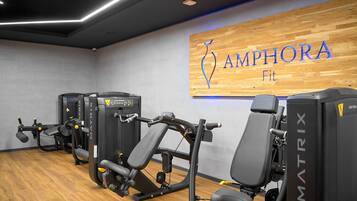Un gimnasio con equipamiento MATRIX y una pared de madera con el logotipo de AMPHORA Fit.