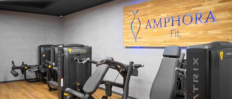 Un gimnasio con equipamiento MATRIX y una pared de madera con el logotipo de AMPHORA Fit.