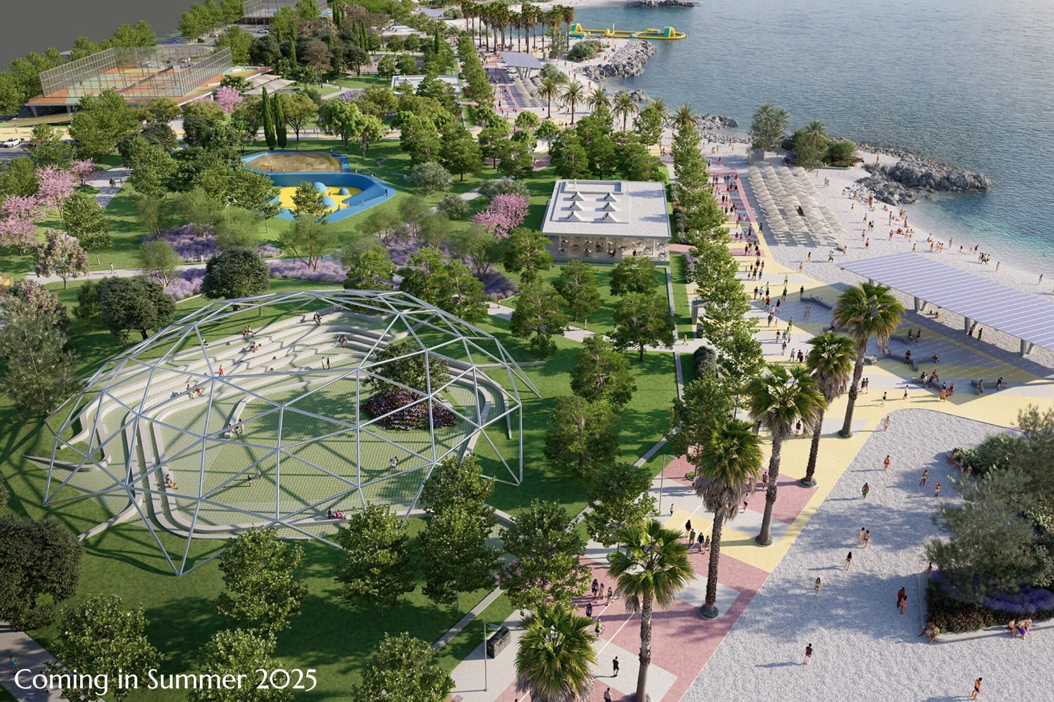 An aerial view of a park with a large geometric structure, a beach area with people, and a building with a sign.